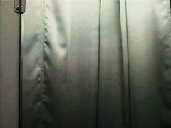 Black haired woman stripping in the store changing room