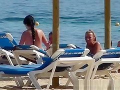 Pretty topless girls sunbathing on the beach