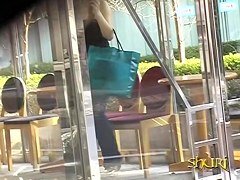 Slim Asian girl engaged into boob sharking on the street.